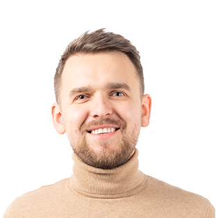 Headshot of a smiling man with short brown hair wearing a beige turtleneck sweater against a white background.