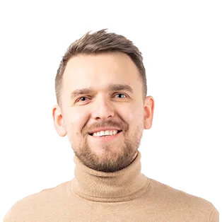 Headshot of a smiling man with short brown hair wearing a beige turtleneck sweater against a white background.