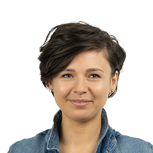 Professional headshot of a woman with short dark hair wearing a denim shirt against a white background.