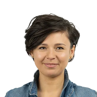 Professional headshot of a woman with short dark hair wearing a denim shirt against a white background.