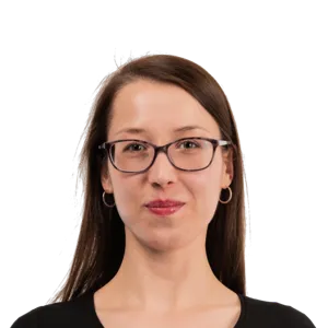 Portrait of a woman with long brown hair, glasses, and a black top against a white background.