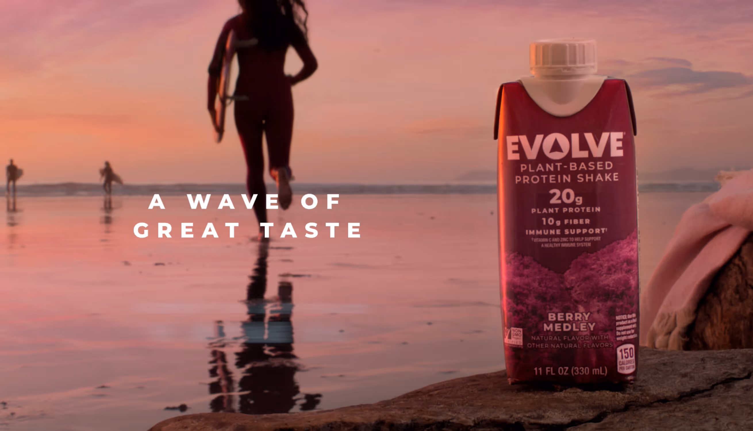 A bottle of Evolve sitting on top of a rock next to a body of water
