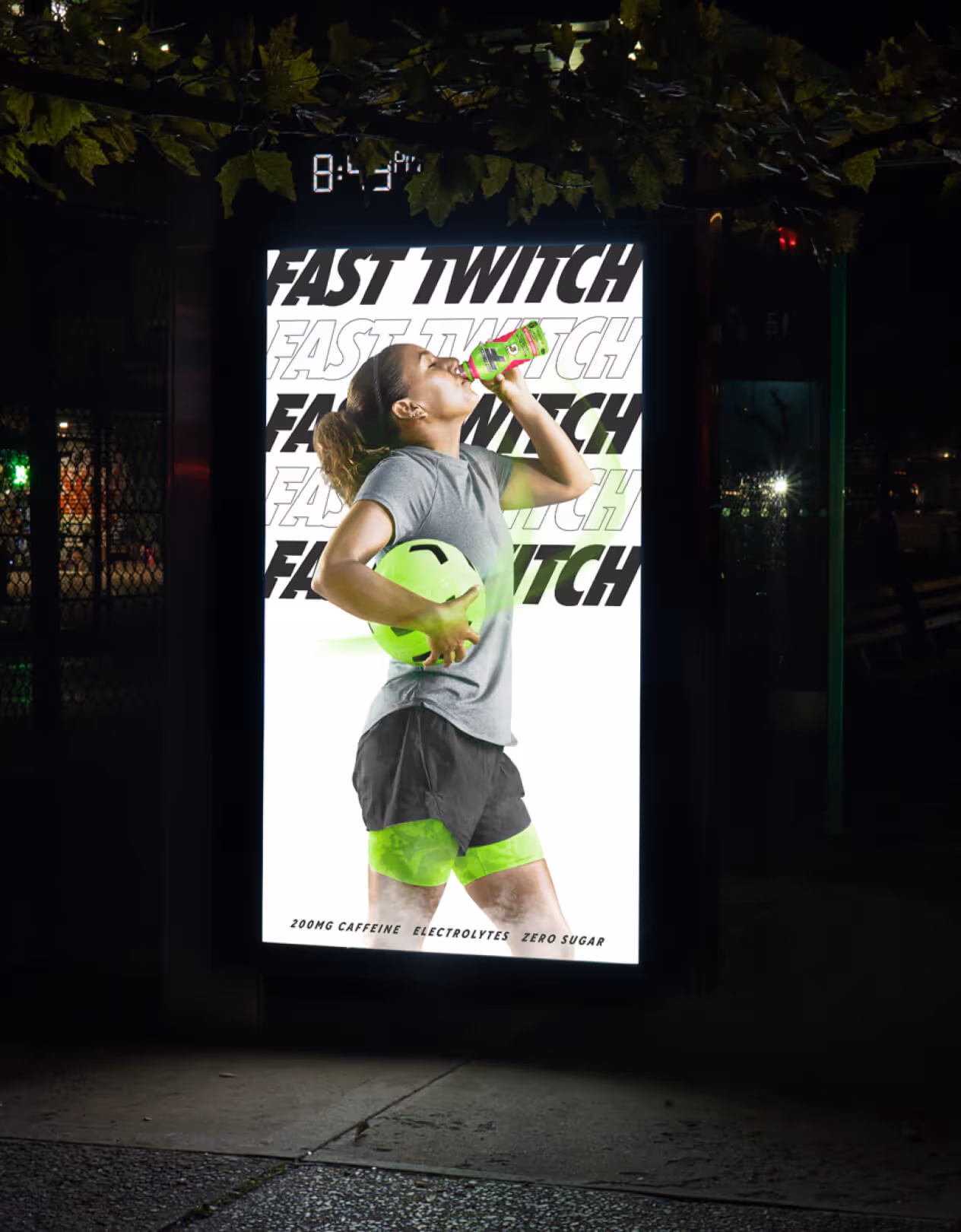 Woman enjoying Fast Twitch sports drink with neon green soccer ball at nighttime.