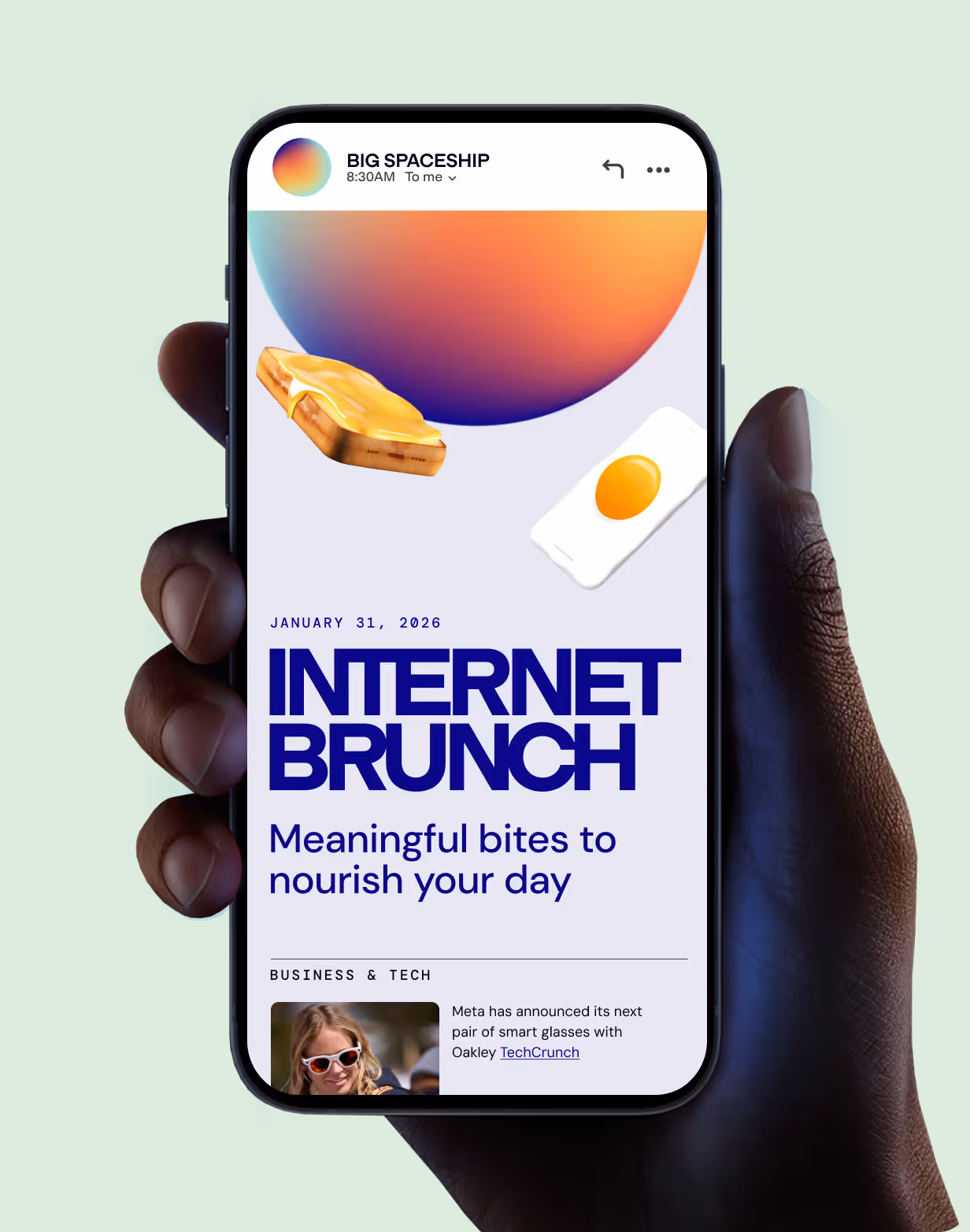 Hand holding a smartphone displaying an email titled 'Internet Brunch' dated January 31, 2026, with toast, fried egg, and colorful planet graphics.
