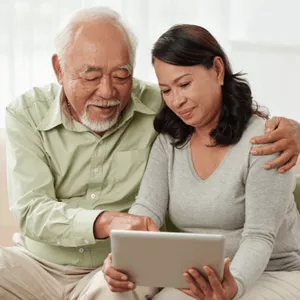 Senior couple engaged in reverse mortgage counseling while using a tablet together.  