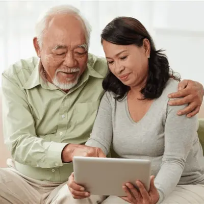 Senior couple engaged in reverse mortgage counseling while using a tablet together.  