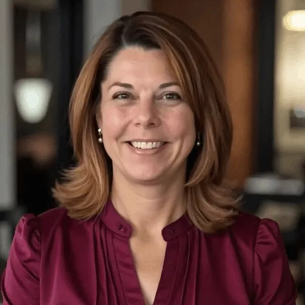 Young woman wearing glasses sitting at a table, reviewing documents with focus, symbolizing organization and financial planning.