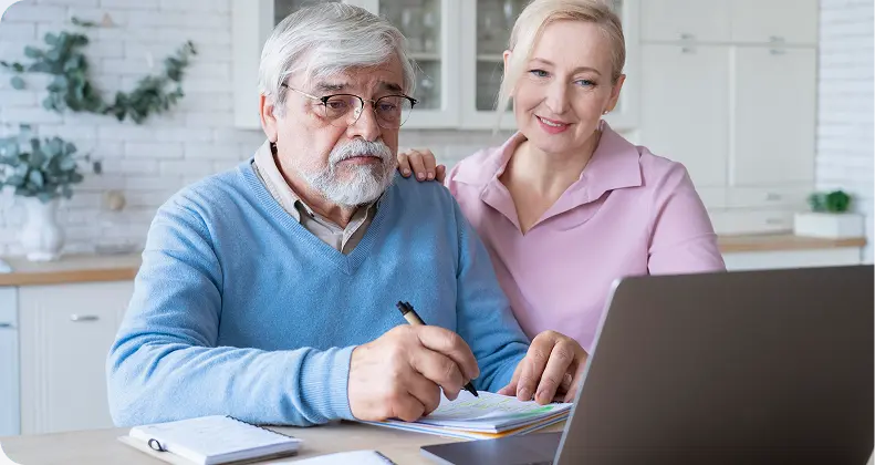 Older couple reviewing finances online and planning for retirement, budgeting, and long-term financial stability.