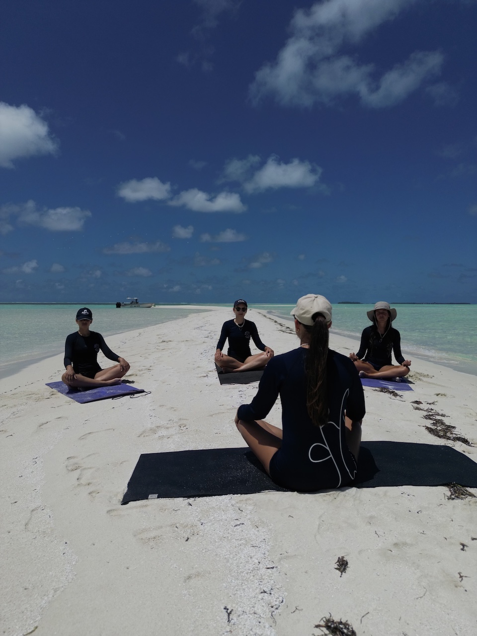 Yoga teaching on a Maldives sandbar at golden hour