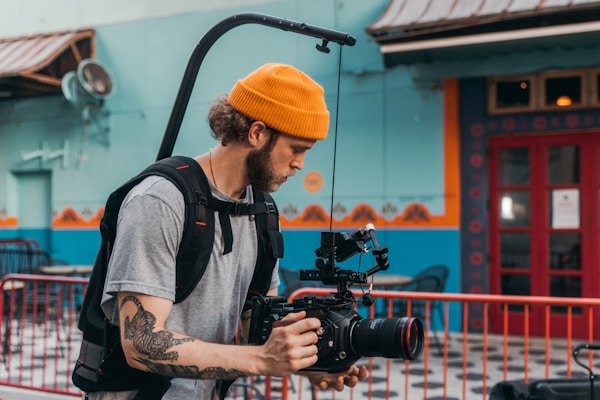 man in gray crew neck t-shirt holding black dslr camera