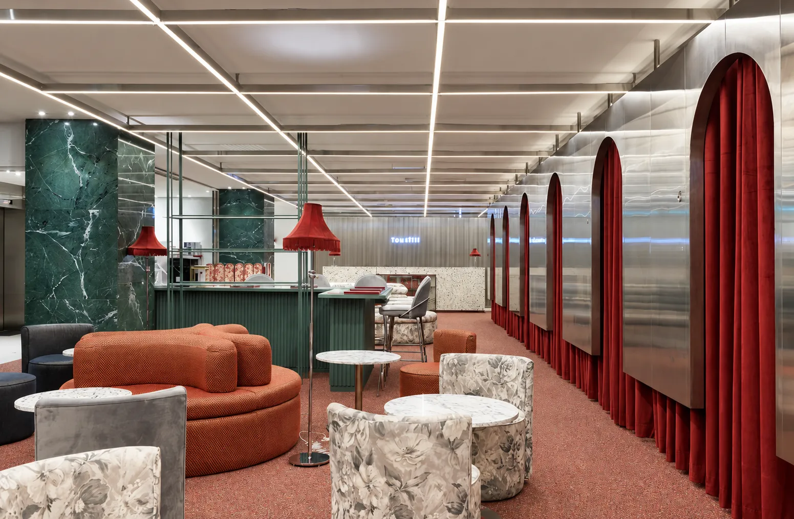 Clinic waiting area with seating, green stone columns and red curtains. AI-enhanced lighting and color.