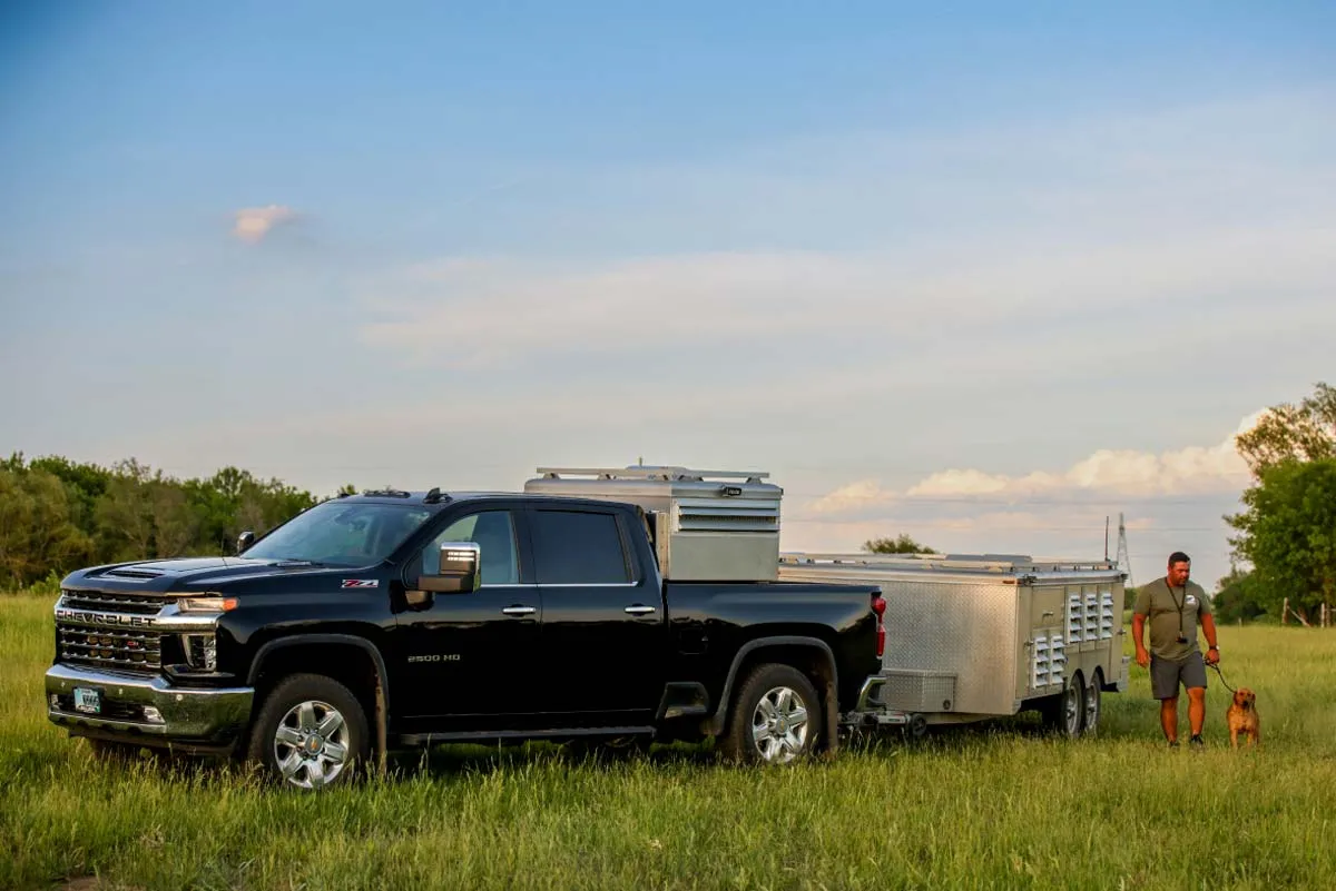 pickup in field with dog kennel trailer