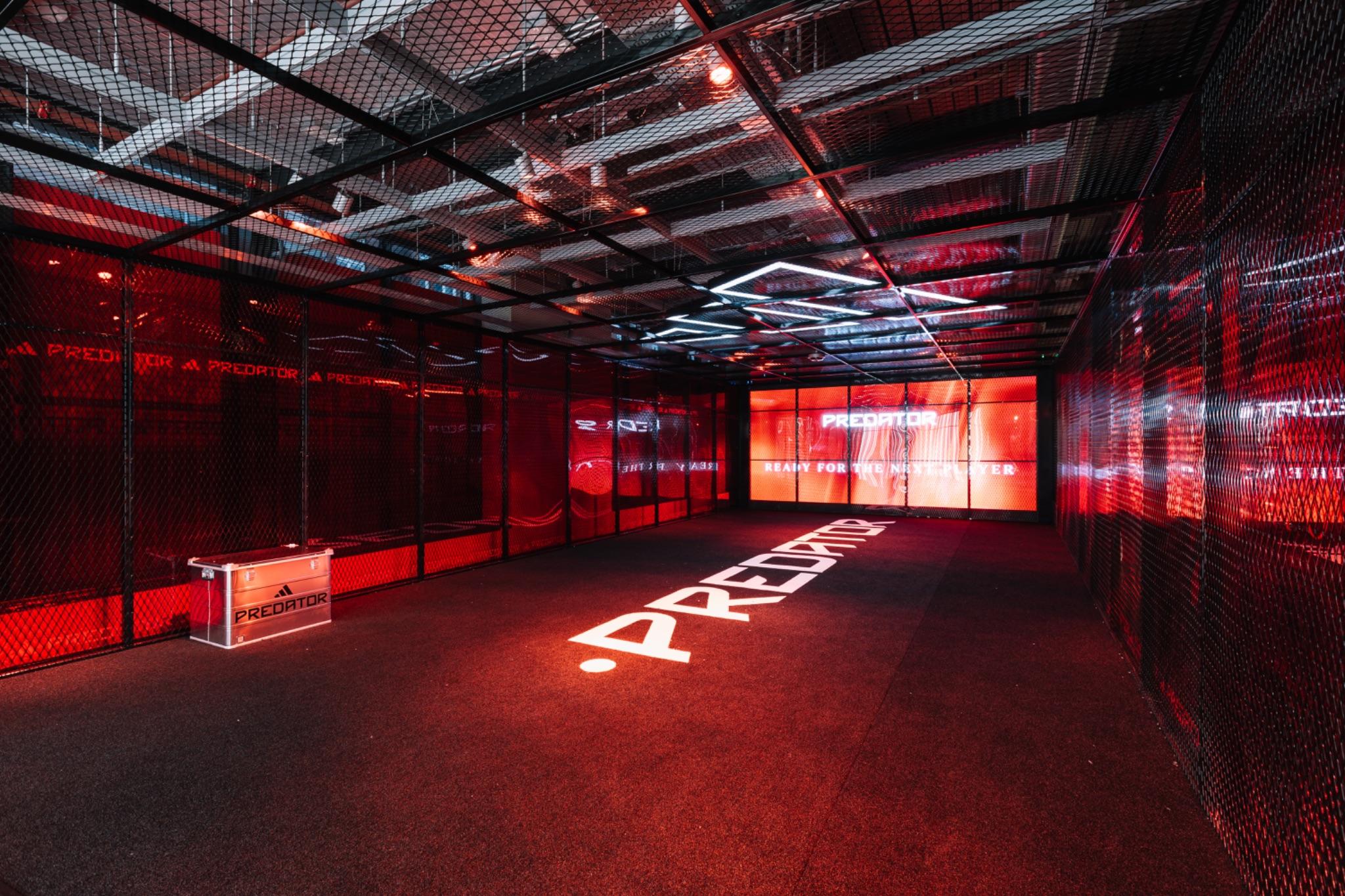 adidas Predator football boot on a red lit retail display