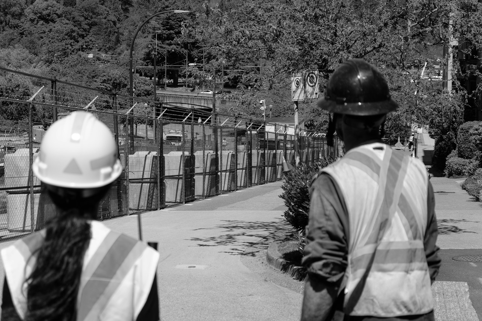 Construction worker in hard hat and safety vest conducting a site inspection with documentation