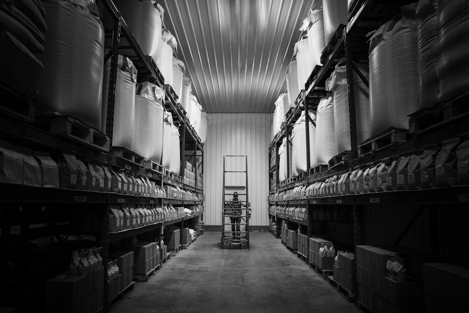 Tall warehouse shelving stacked with boxes, representing the goods-receipt step verified during automated three-way purchase order matching
