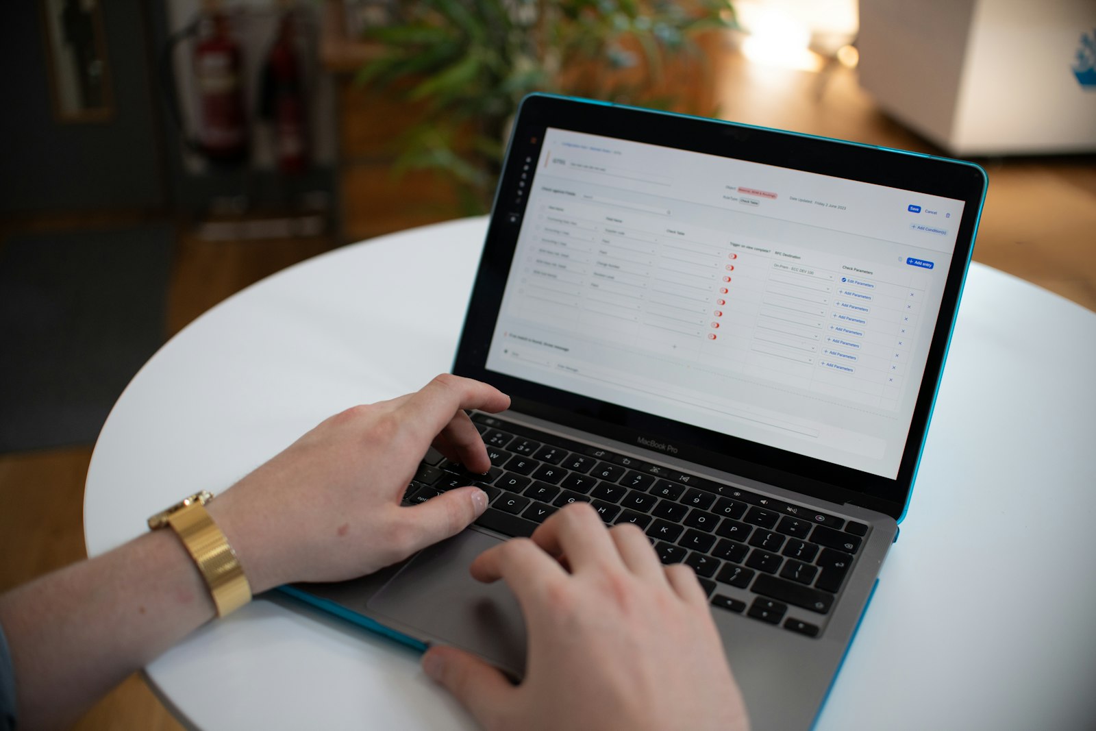 Hands typing on a laptop showing a financial spreadsheet, representing the manual back-office work that straight-through processing automates