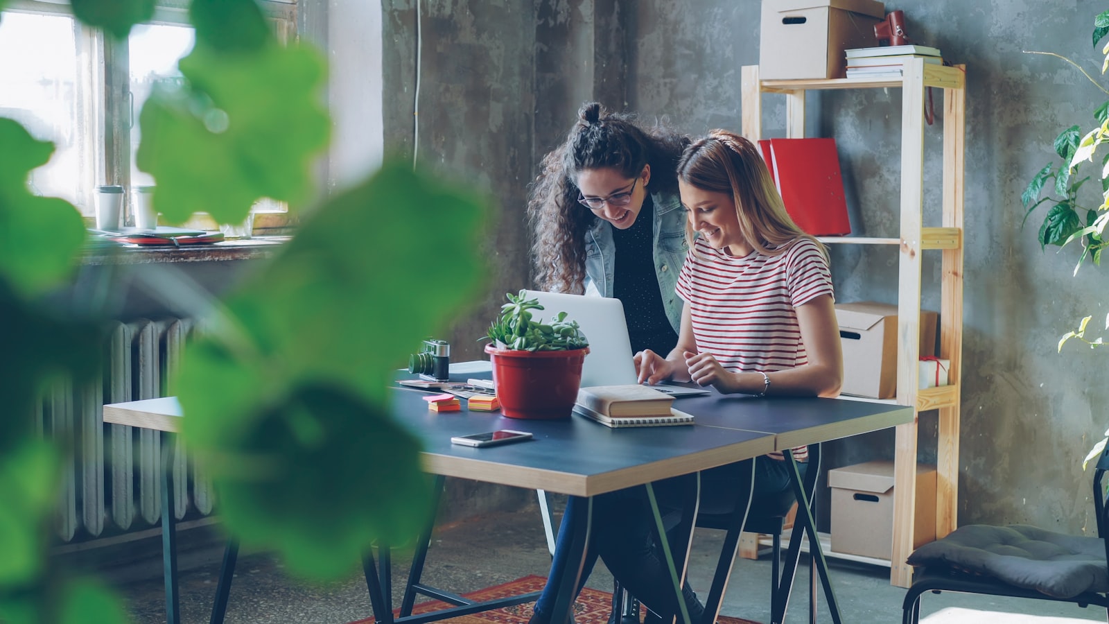 Two business colleagues collaborating at a laptop in a modern office during a customer onboarding session