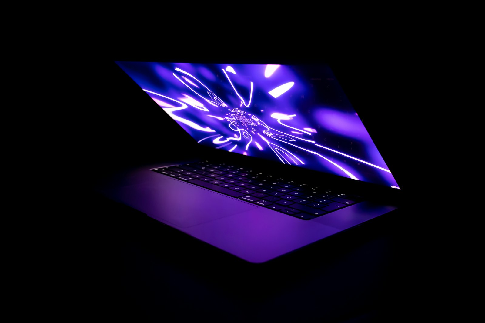 A laptop glowing in a dark office, evoking unsanctioned shadow AI tools running unseen inside a company