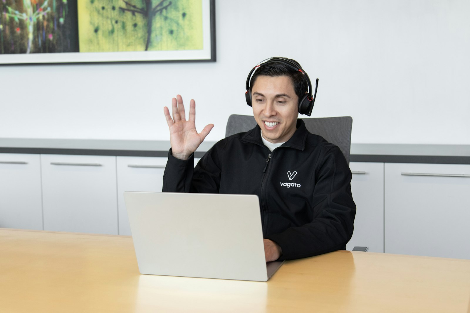 IT support specialist wearing a headset at a workstation, ready to resolve service desk tickets in a corporate office