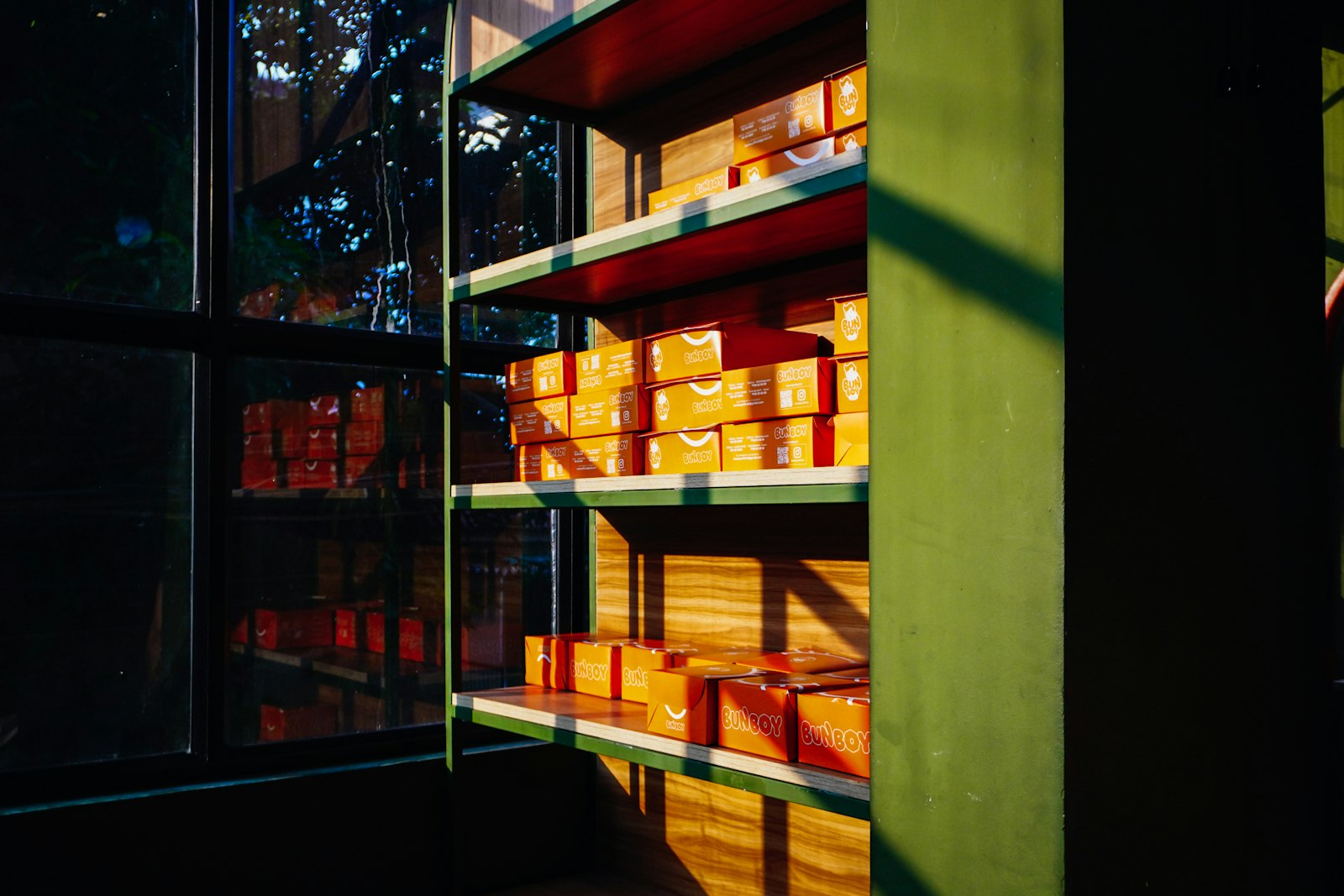 Warehouse shelves neatly stacked with rows of orange boxes in natural light, representing organized inventory records