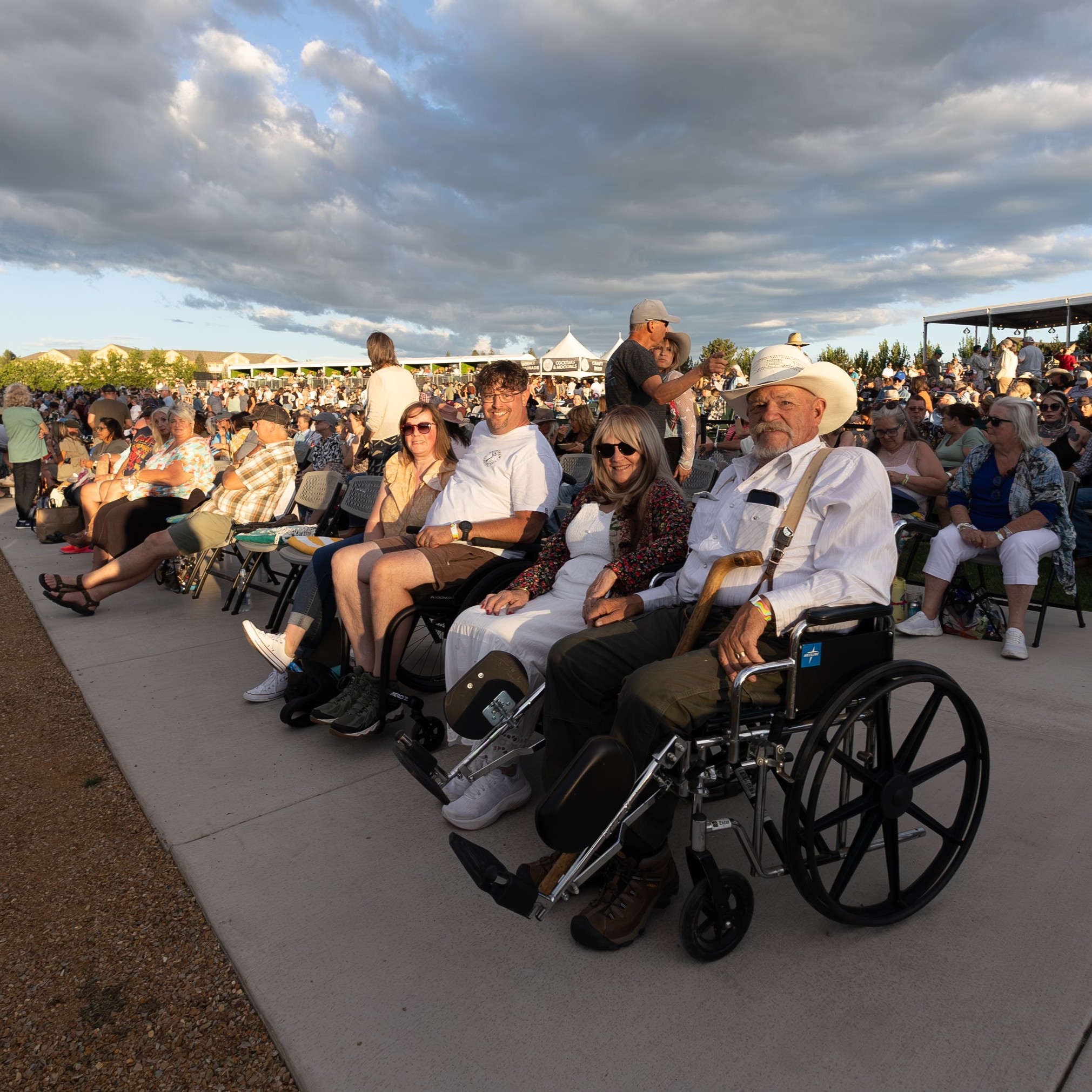 Man in with family seated in accessible seating area at Hayden Homes Amphitheater in Bend, Oregon