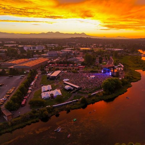 Aerial view of Hayden Homes Amphitheater during a sold out show at dusk with the Deschutes River and Pilot Butte in the background