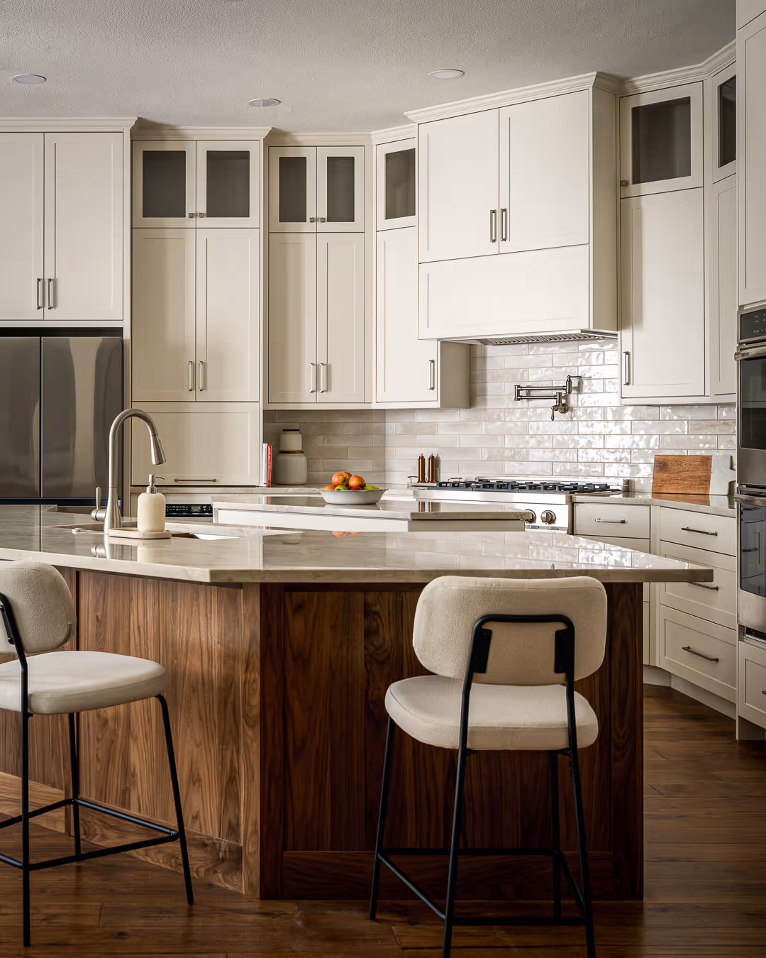 Modern kitchen remodel with white cabinets, a large marble countertop island, in Cedar Park, TX.