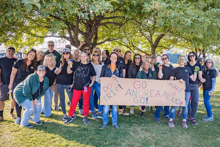 Hayden Homes Amphitheater staff holding up a sign to cheer on another staff member trying to sprint to the stage for Dave Matthews Band