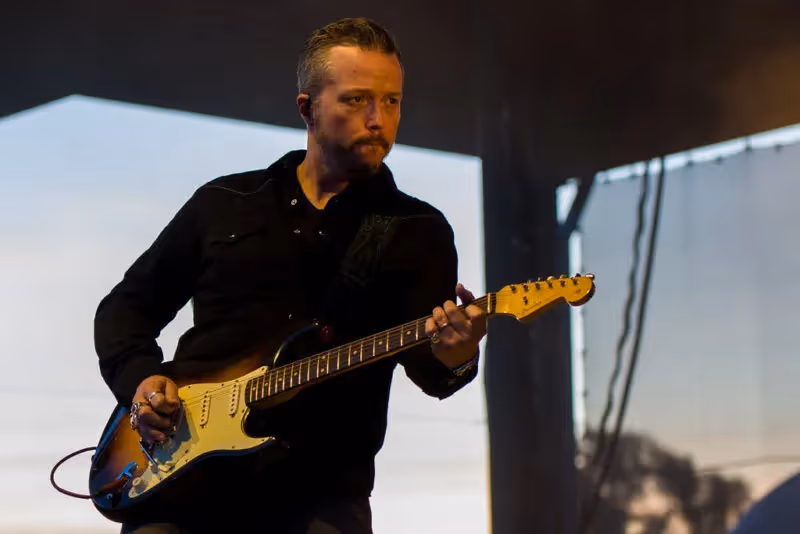 Photo of Jason Isbell playing his guitar looing into the crowd