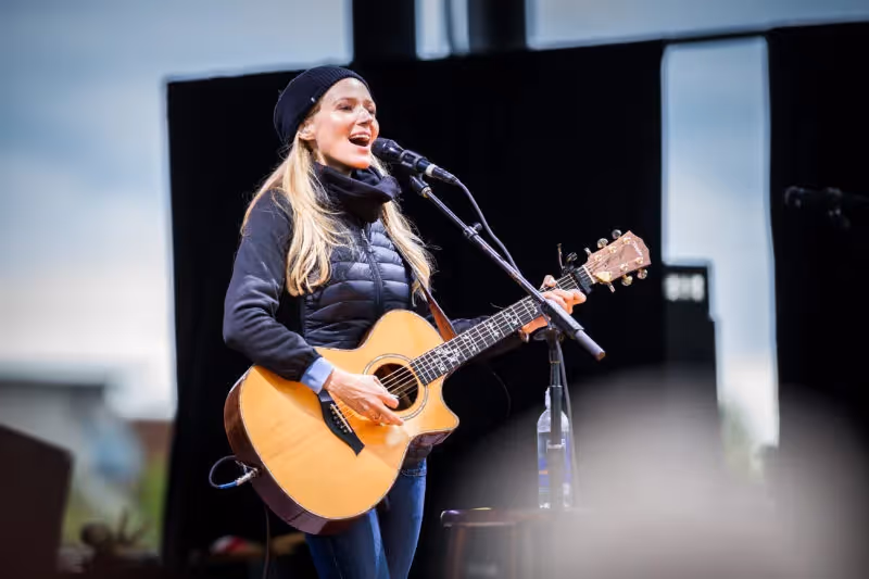 Artist Jewel singing and playing her guitar in 2017