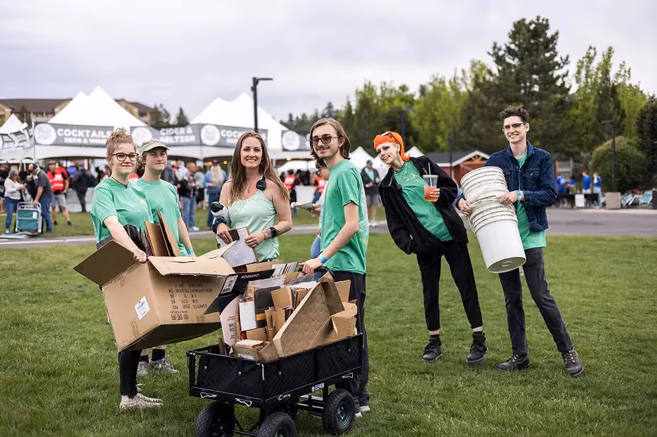 The Green Team cleaning up the venue and smiling for the camera while they promote sustainability at concerts