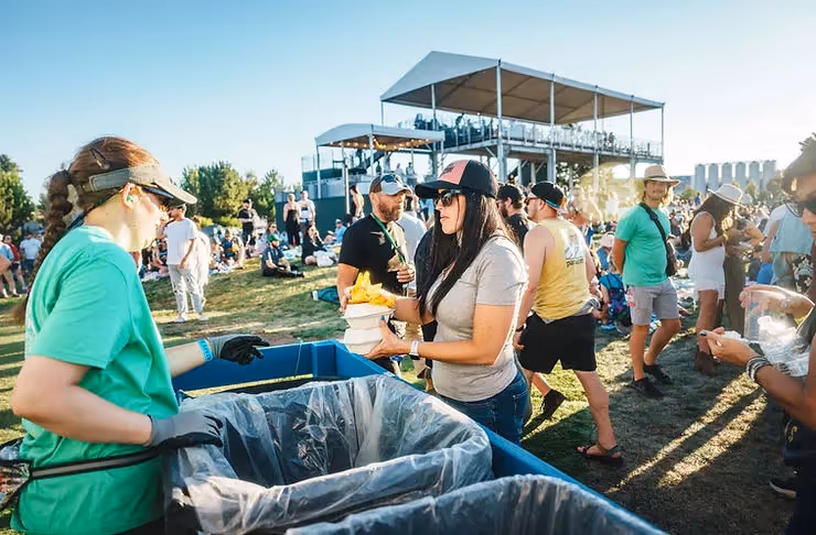 Green Team member and concertgoers talking through which receptacle to put waste in at a summer concert