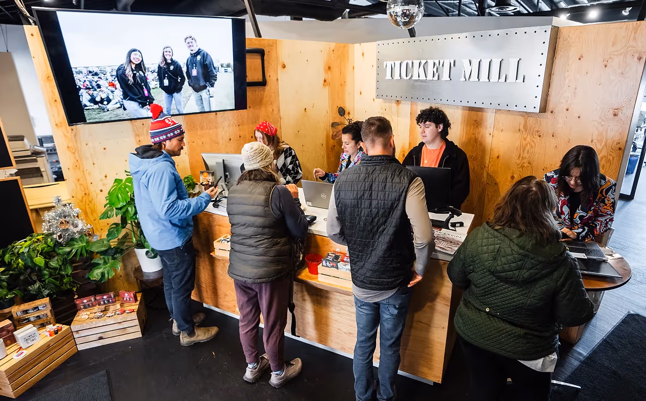 Ticket Mill staff happily assisting concertgoers with tickets to a show.