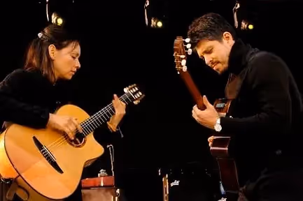 man and woman playing acoustic guitar
