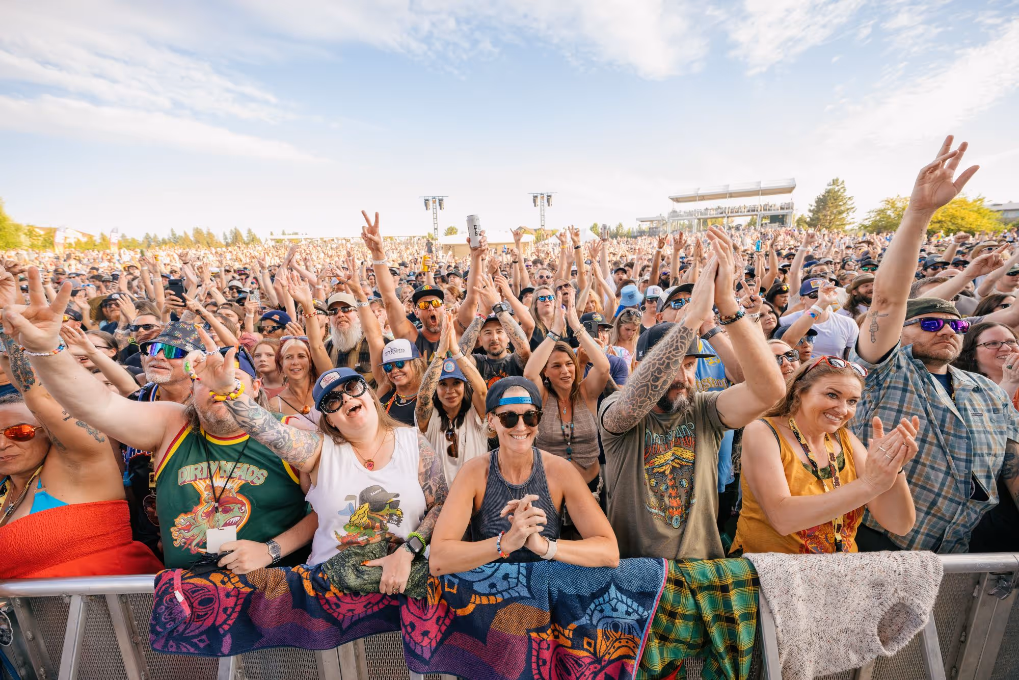 Reggae fans cheering at the barricade on a sunny summer day at the Slightly Stoopid Concert at Hayden Homes Amphitheater
