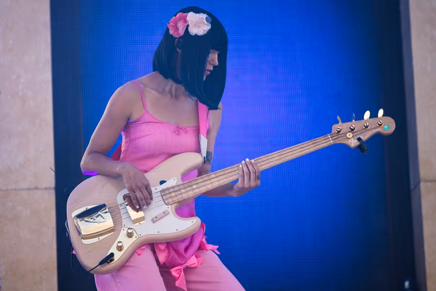 Khruangbin lead bass guitar player in a gorgeous pink jumpsuit rocking out at Hayden Homes Amphitheater in Bend, Oregon.