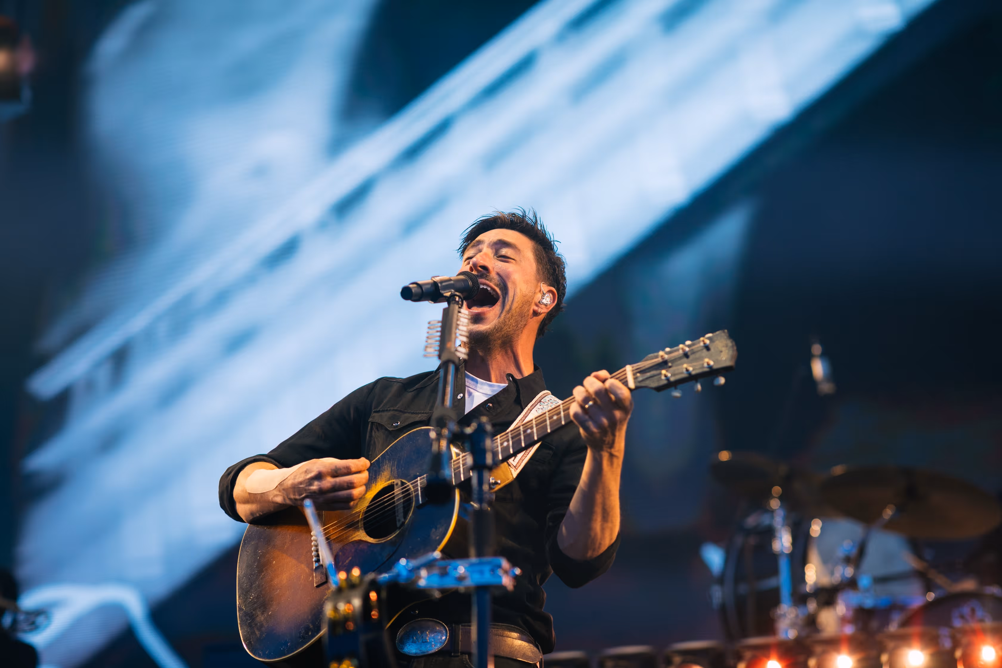 Marcus Mumford of Mumford & Sons singing his heart out on stage at Hayden Homes Amphitheater in Bend, Oregon