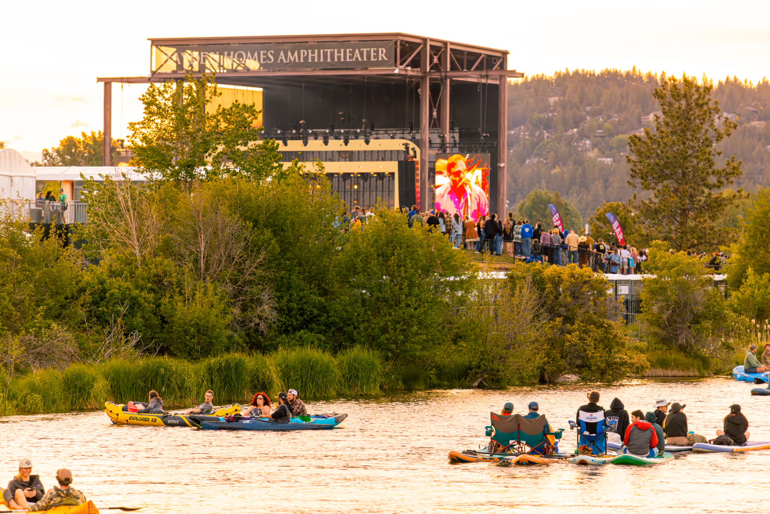 Folks floating the Deschutes River through the Old Mill District during a concert at Hayden Homes Amphitheater