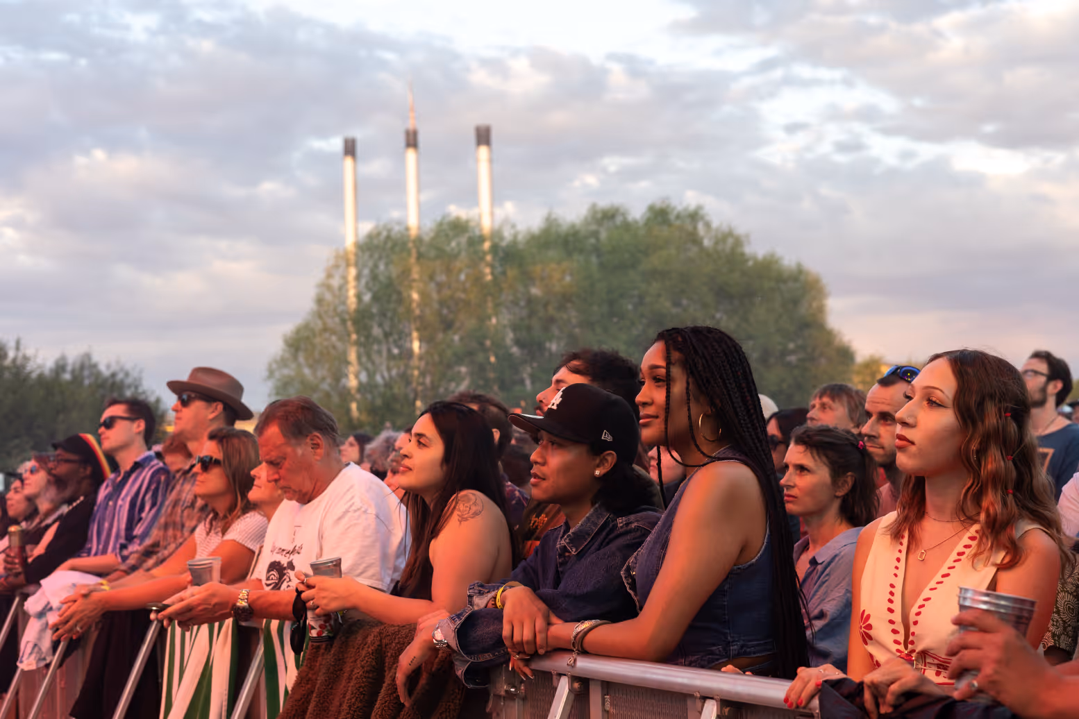 Fans mesmerized at the front while watching a concert at Hayden Homes Amphitheater in Bend, Oregon with the Old Mill District stacks in the background