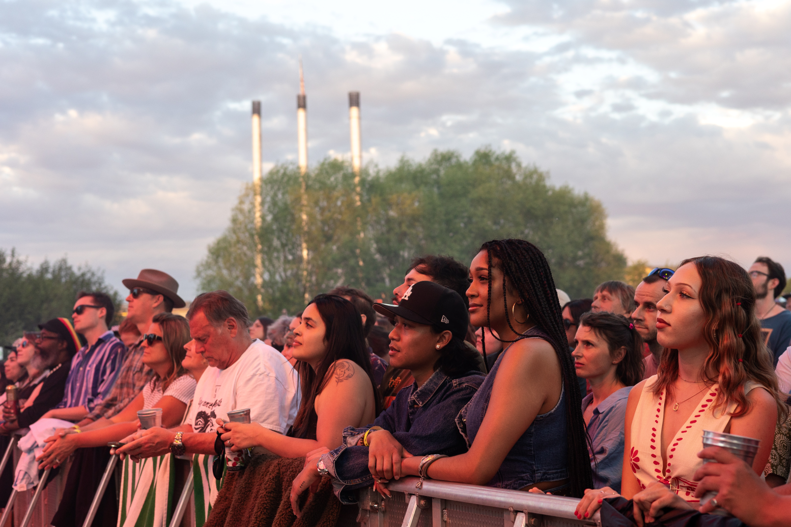 Fans mesmerized at the front while watching a concert at Hayden Homes Amphitheater in Bend, Oregon with the Old Mill District stacks in the background