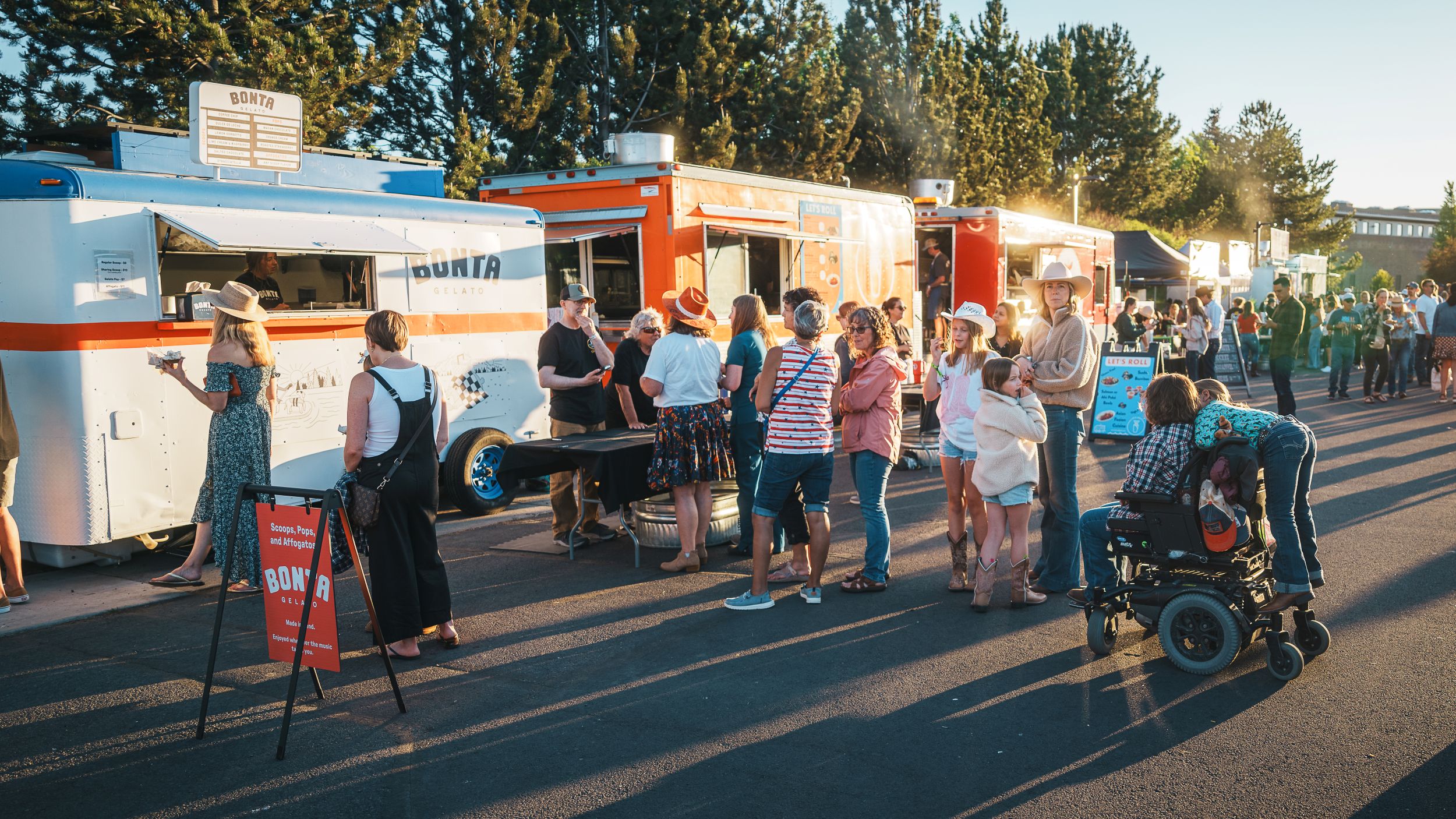 Wide shot of Food Vendor Row at Hayden Homes Amphitheater showcasing eight local food truck concepts.