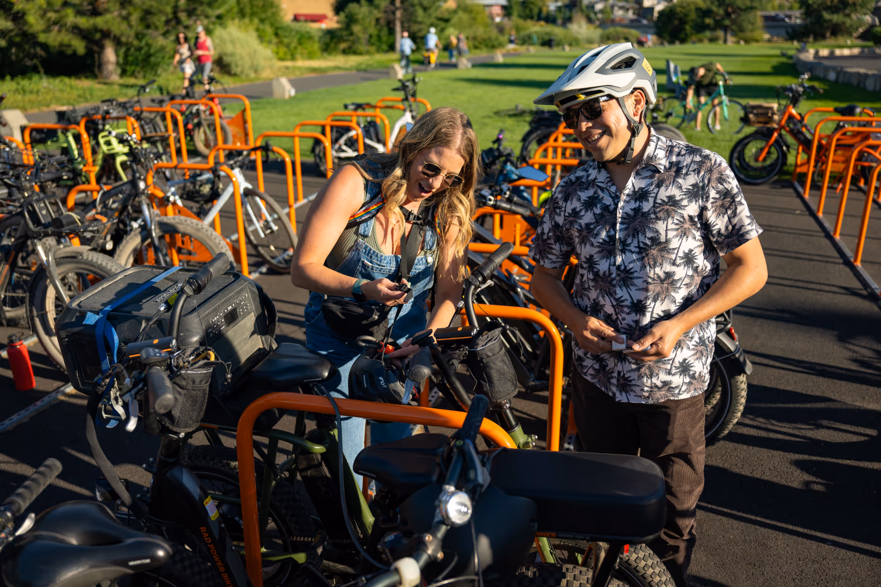 Two concertgoers choosing sustainable transportation and locking up their bikes at the rack in front of Hayden Homes Amphitheater in Bend, Oregon.