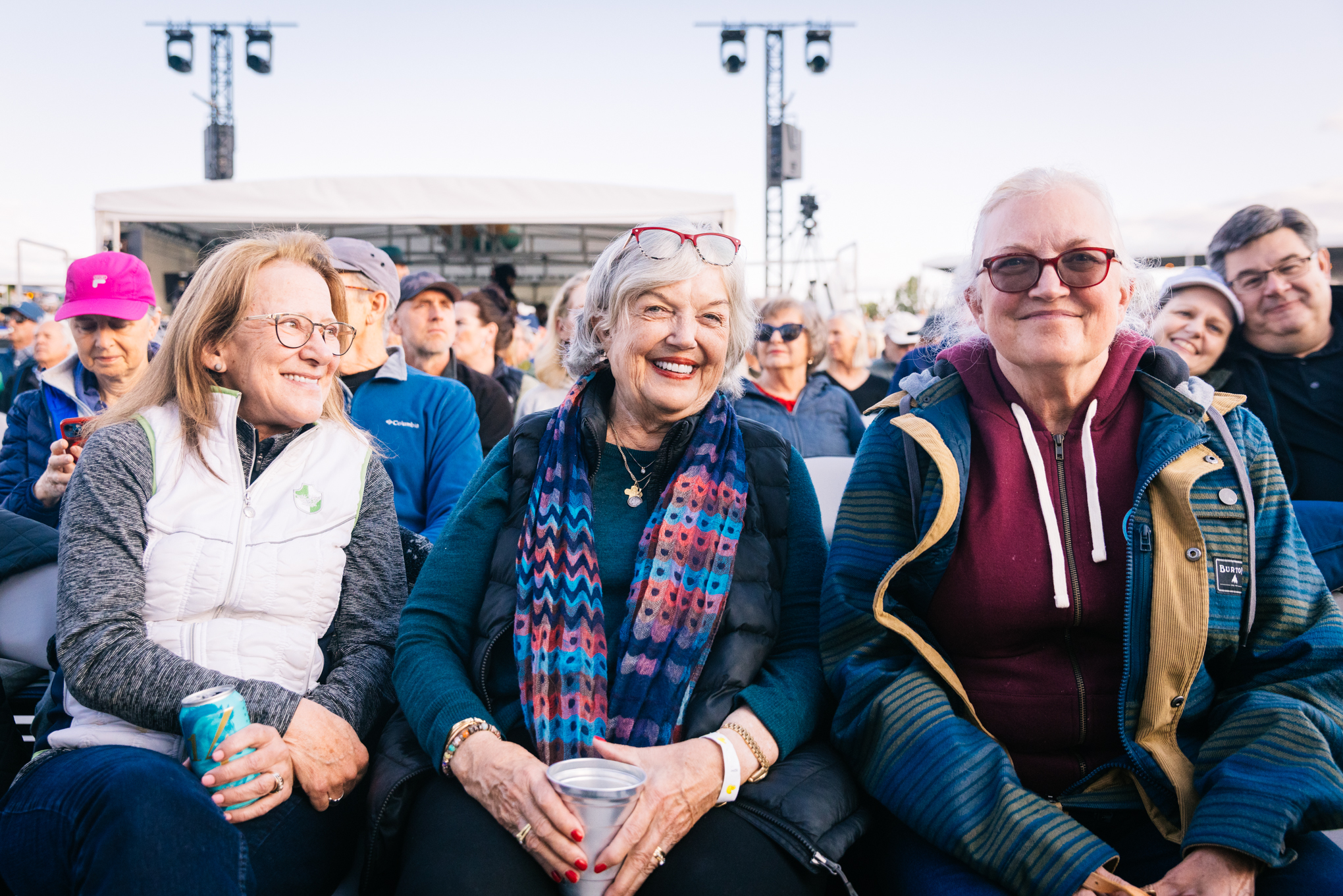 Photo of Old Mill District co-founder, Trish Smith, smiling in her seat during an Earth, Wind, and Fire concert at Hayden Homes Amphitheater in Bend, Oregon.