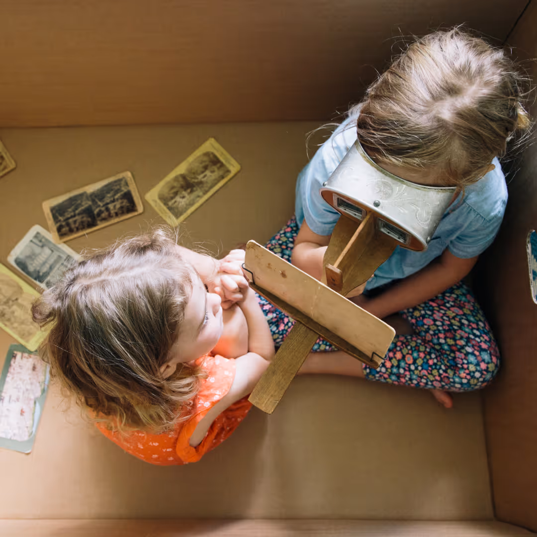 Sisters In A Cardboard Box with A Stereoscope