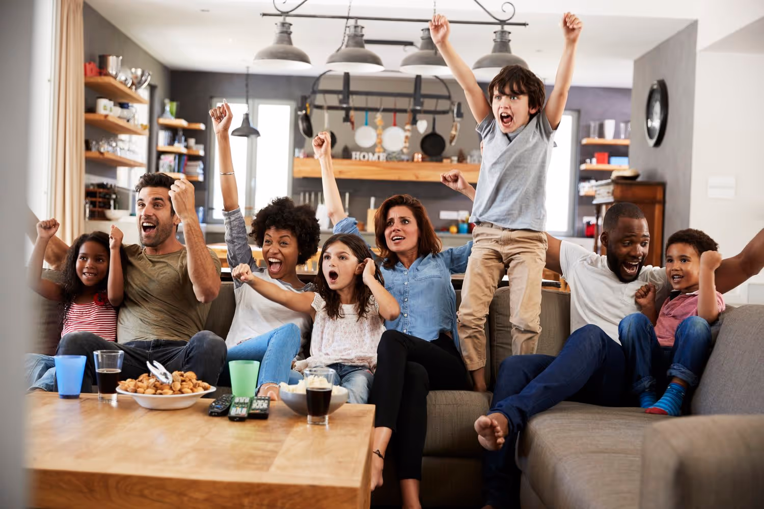 A group of excited people of various ages cheer and celebrate together