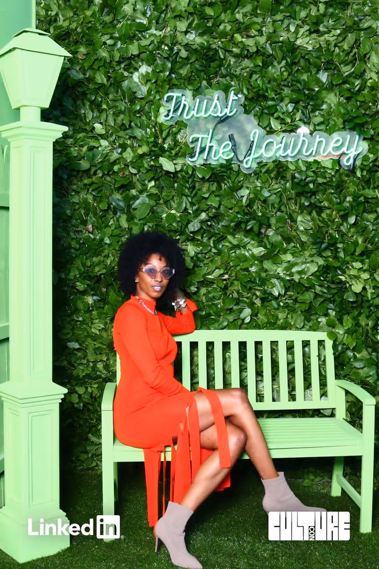 A woman sits on a green bench