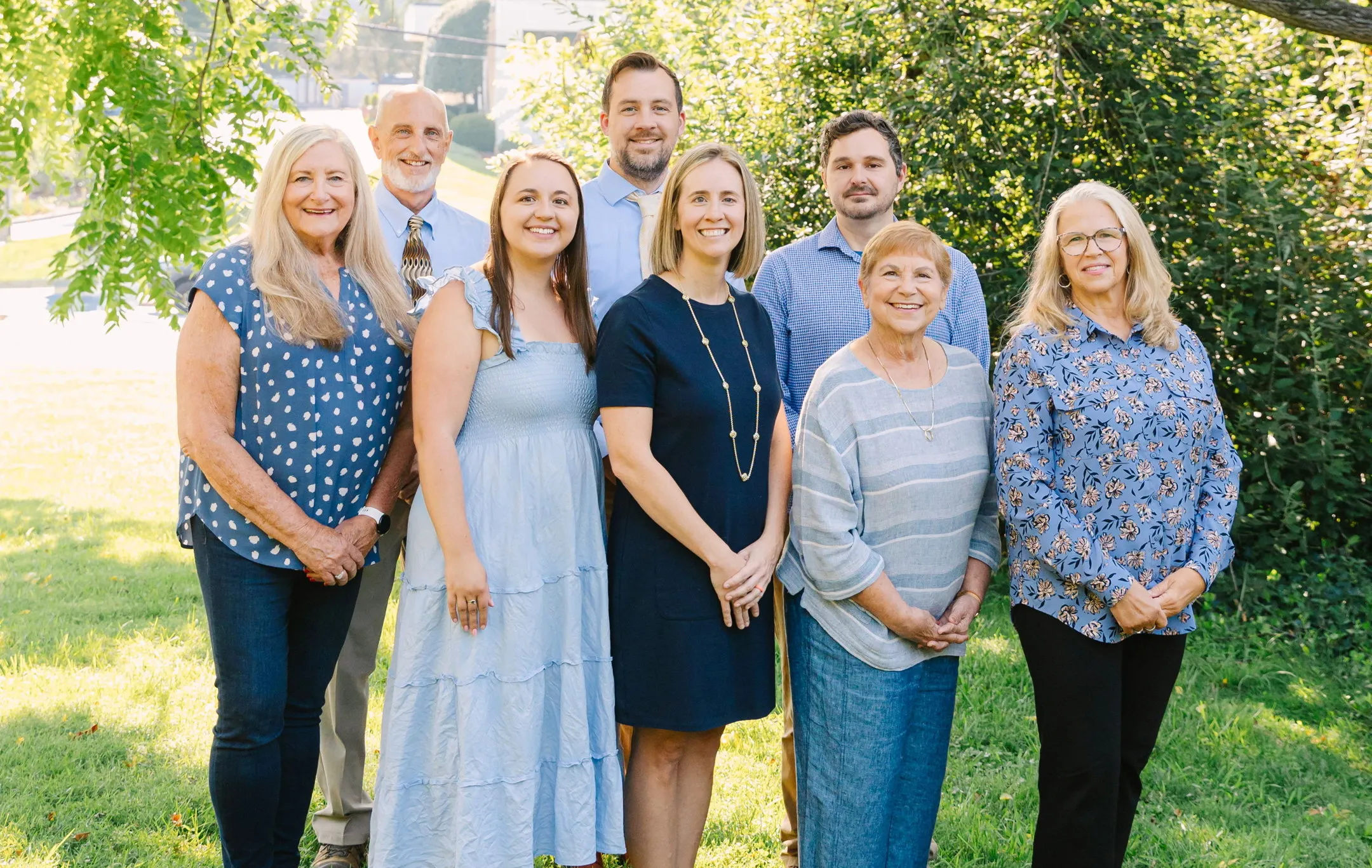 A group photo of JVG's staff outdoors on a sunny day.