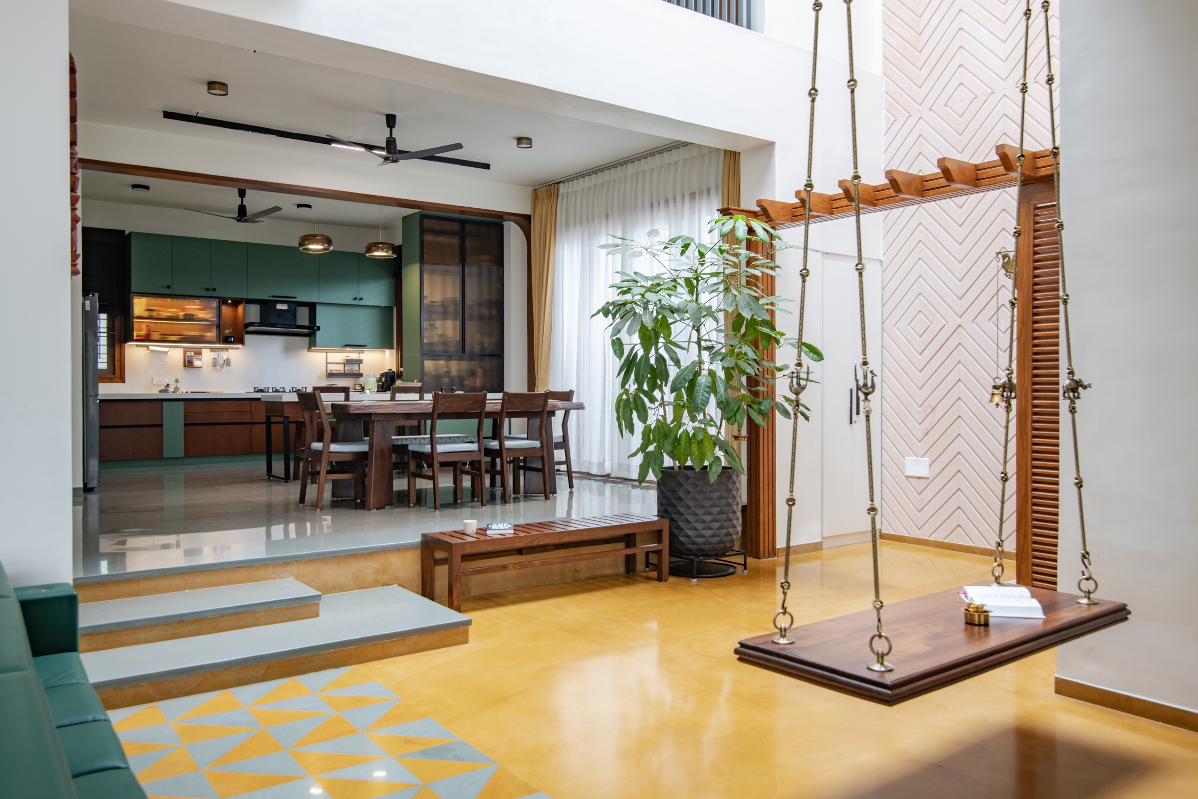 Raised dining area and green kitchen beside a timber swing and yellow floor