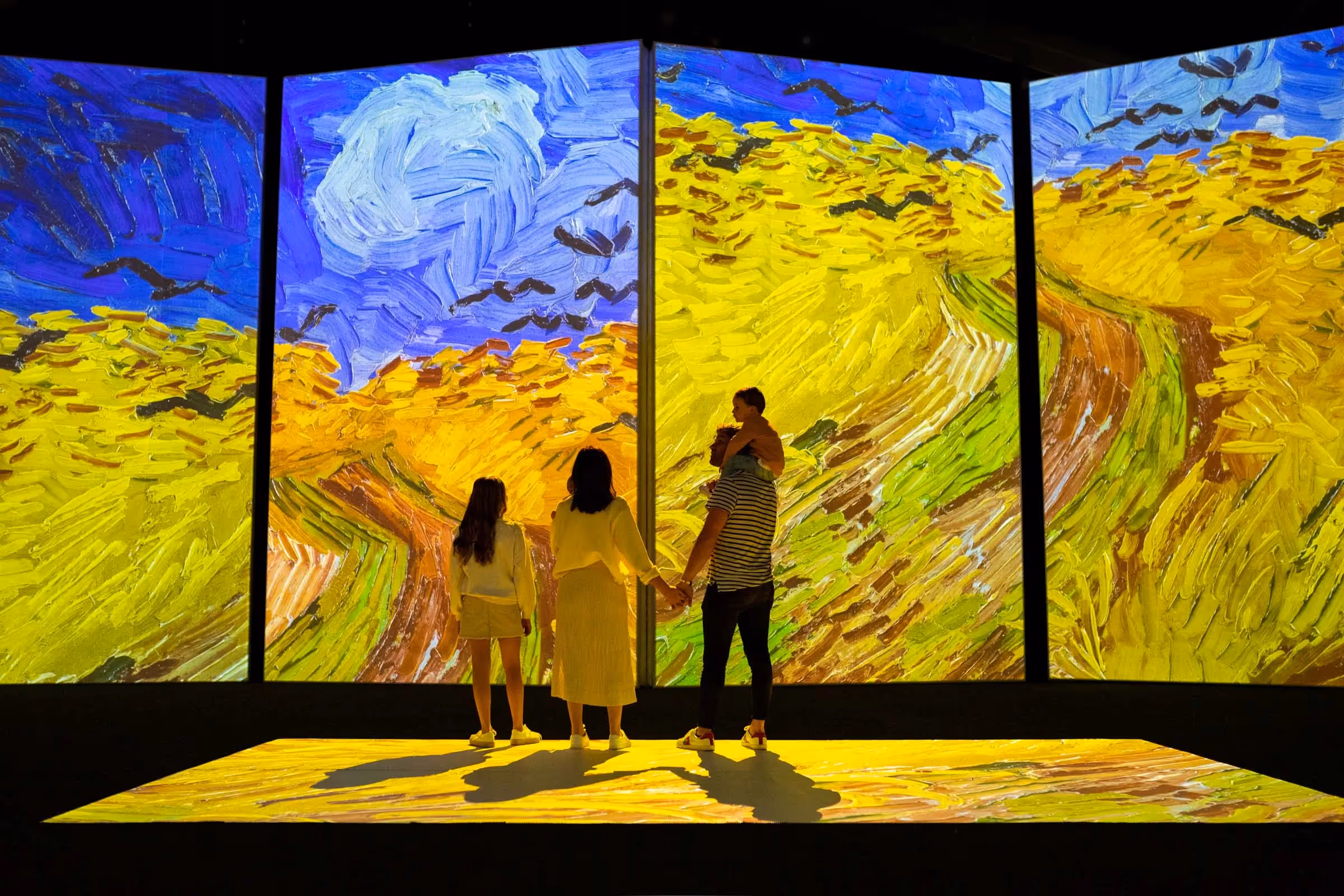 Immersive experience — three visitors inside a stunning digital art installation