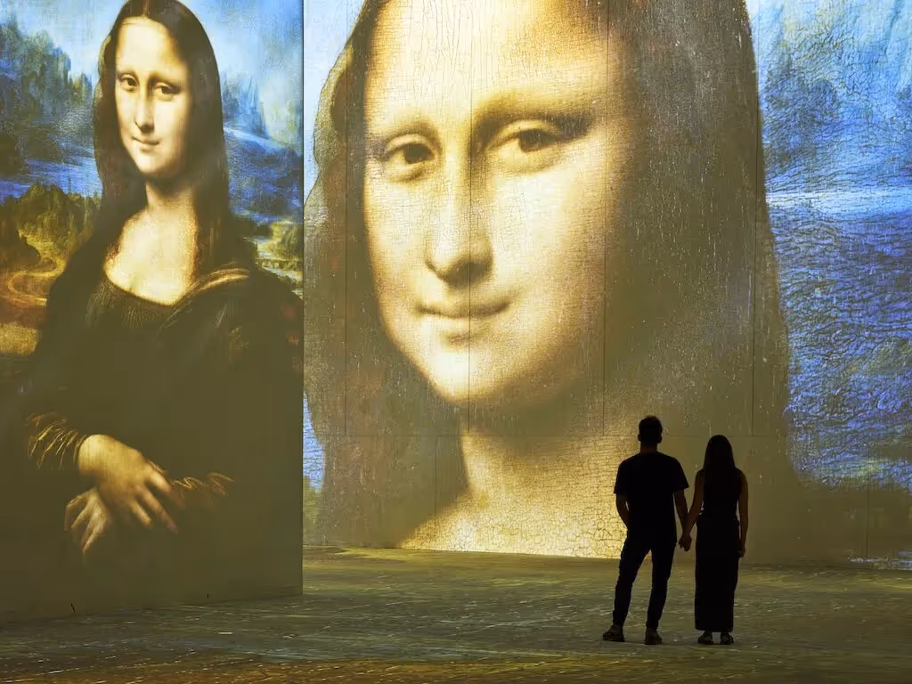 The Mona Lisa at huge scale with a couple silhouetted in front of it. i.
